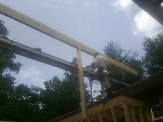 Carpenter setting a ridge beam over a new addition frame — Ice Dam Removal by Roofing Brothers in Broadview
