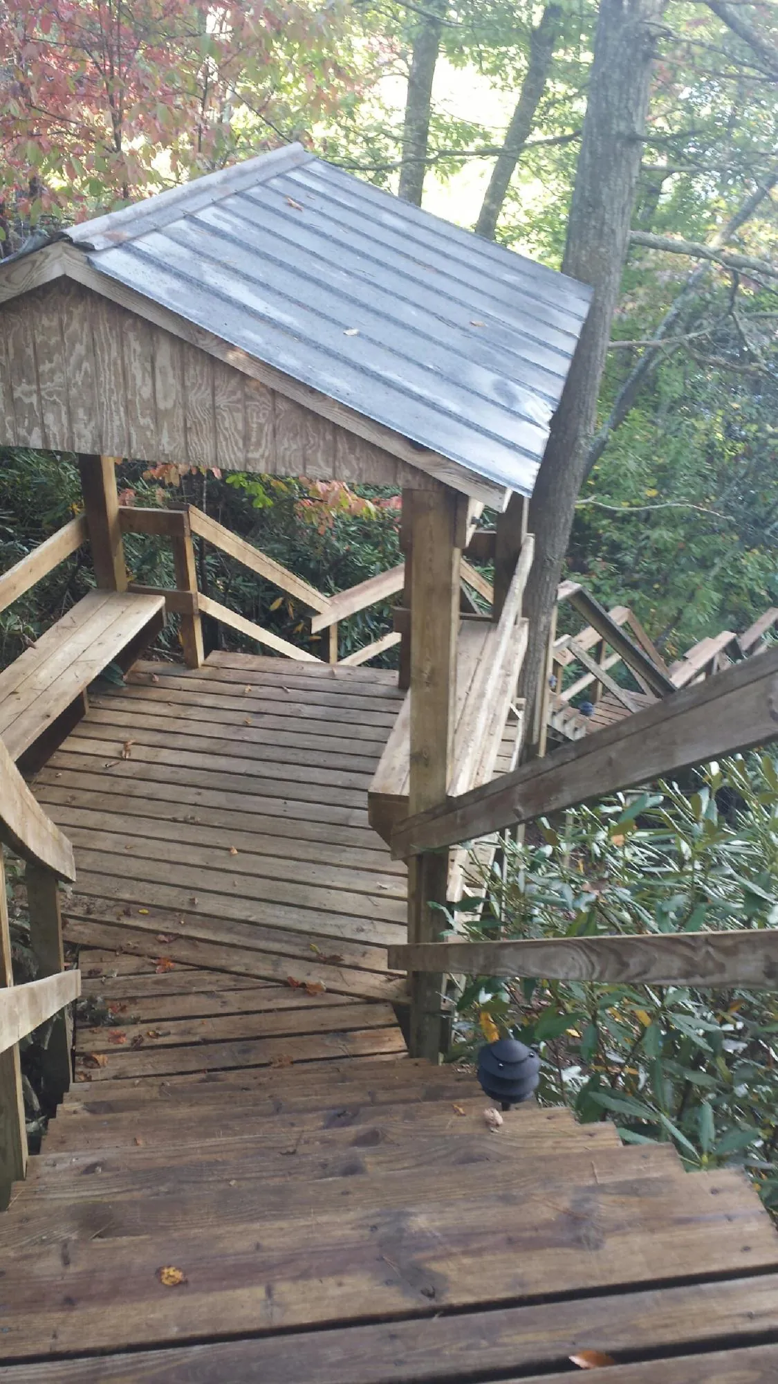 Metal roofed shelter over wooden steps on a wooded walkway — Skylight Repair & Installation work by our crew in Broadview